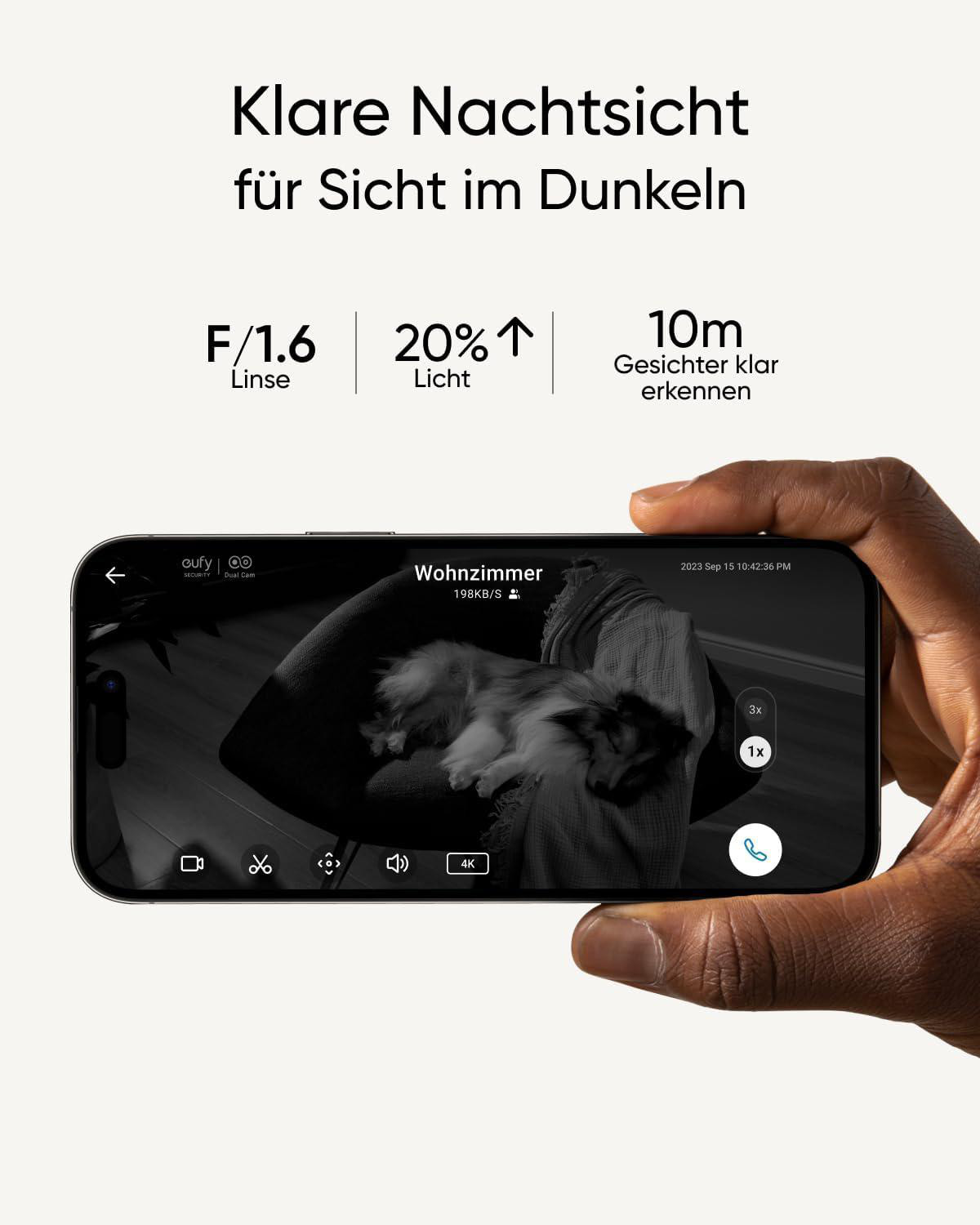 Eine Hand hält ein Telefon, das eine Live-Aufnahme eines Raumes im Dunkeln mit Textüberlagerung zeigt.