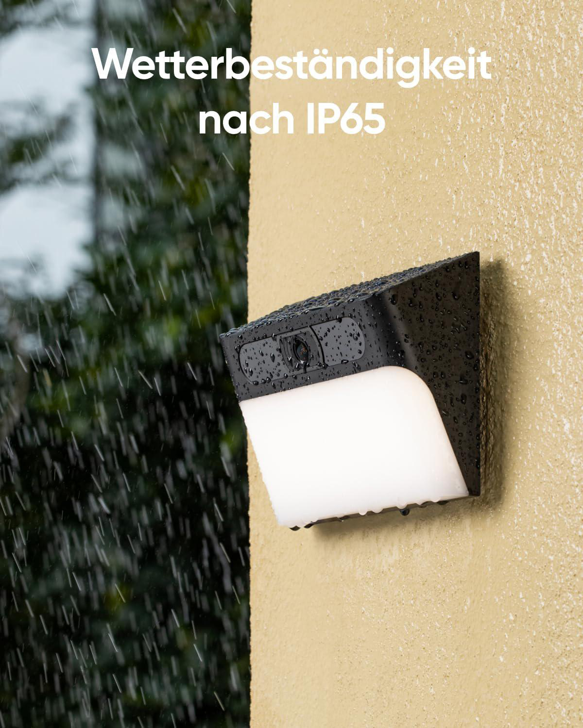 Schwarzes Sicherheitslicht an einer Wand, Regentropfen darauf. Weißes Licht scheint von unten.