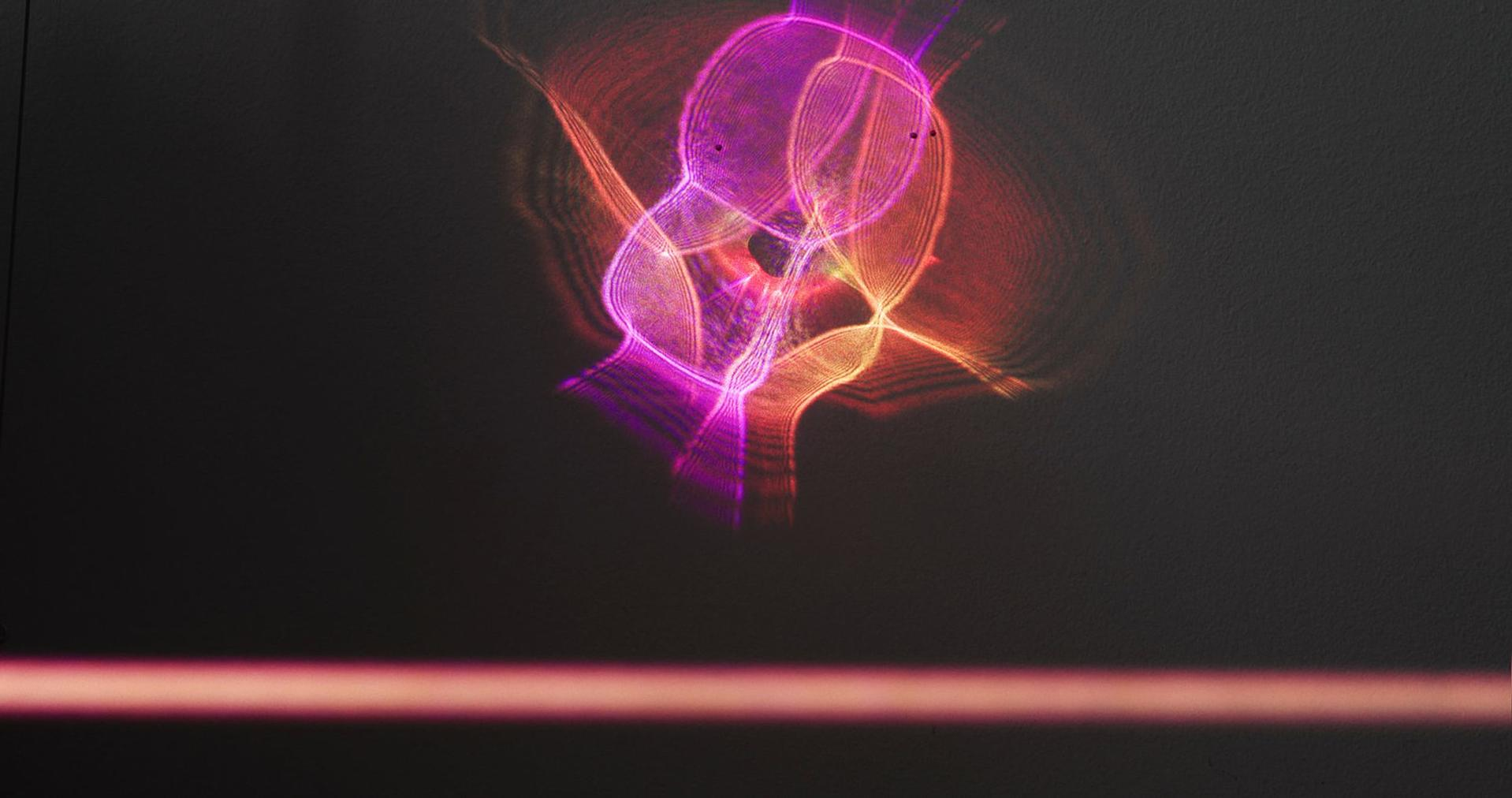 Abstrakte Lichtkunst auf dunkler Oberfläche, rot und lila.