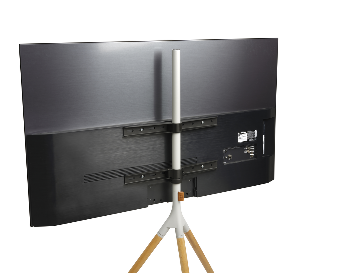 La parte trasera de un televisor en un soporte de trípode. El televisor es negro y tiene puertos de conexión.