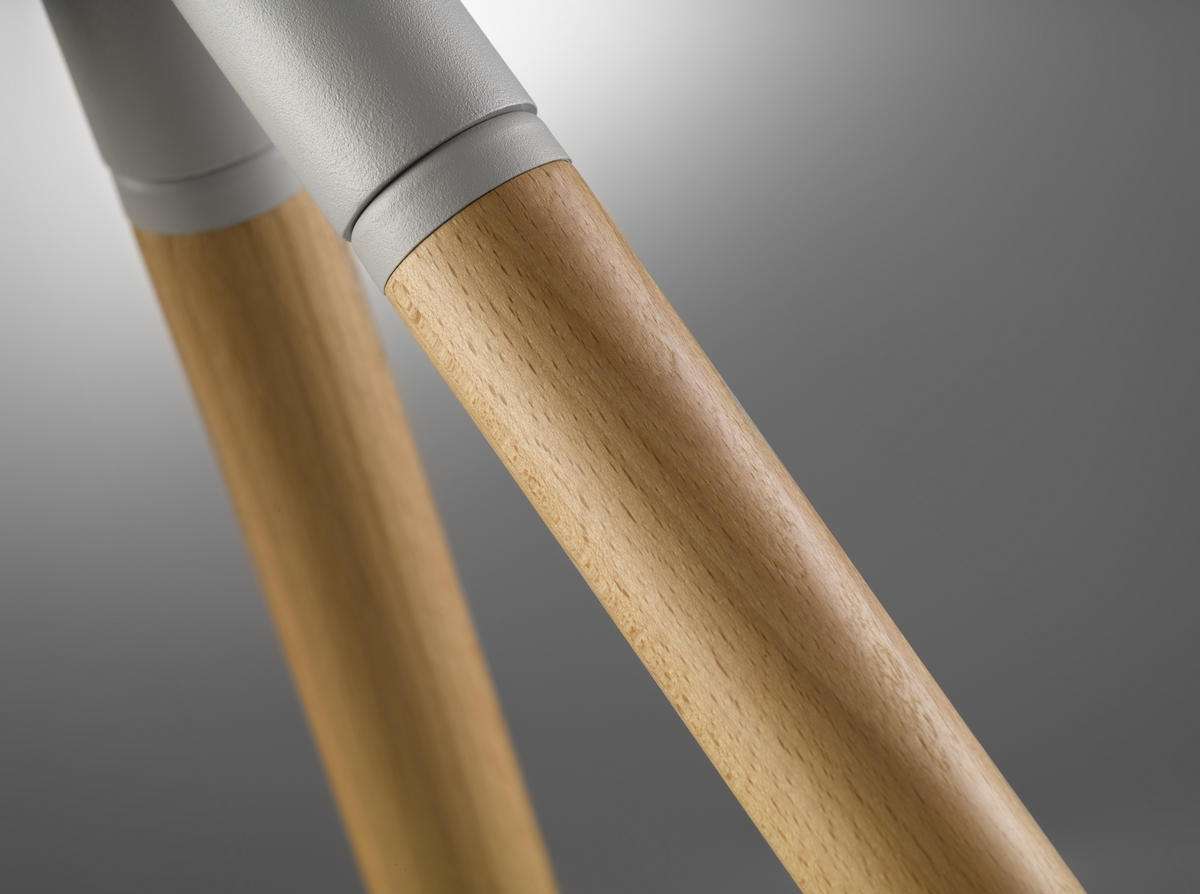 Primer plano de las patas de madera de un soporte de TV. La madera es marrón claro.