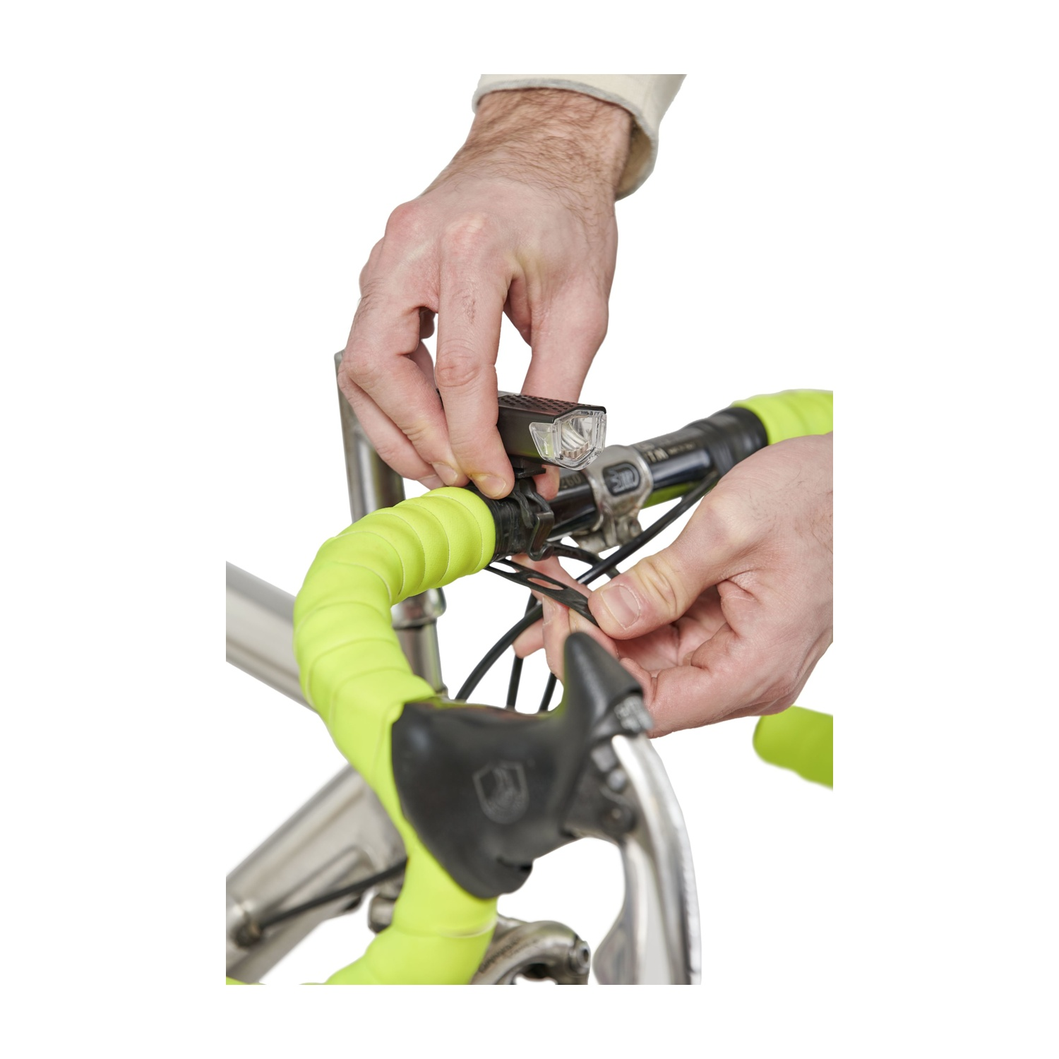 Mani che montano una luce per bicicletta sul manubrio. Nastro verde.