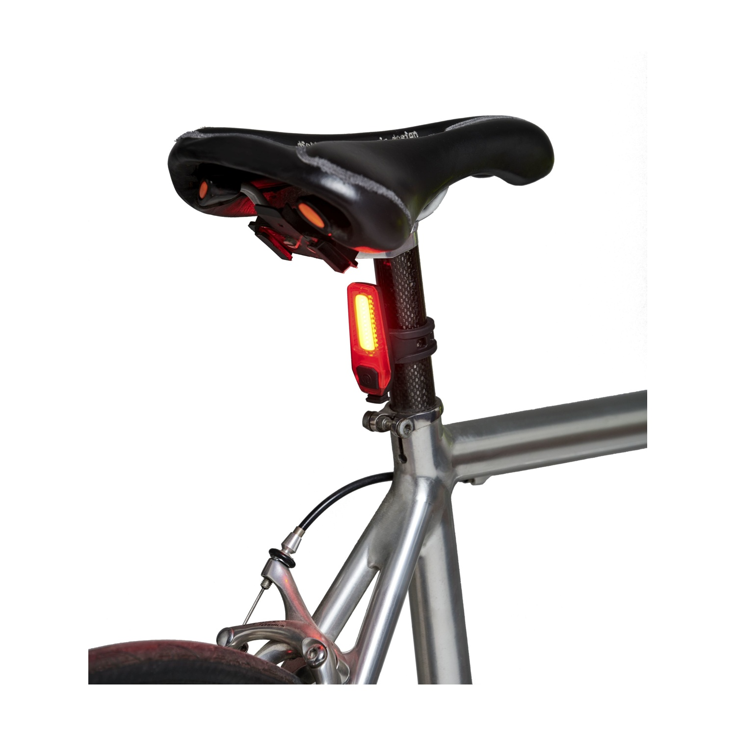 La parte posteriore di una bicicletta con una luce di sicurezza rossa attaccata al reggisella. La luce è accesa.
