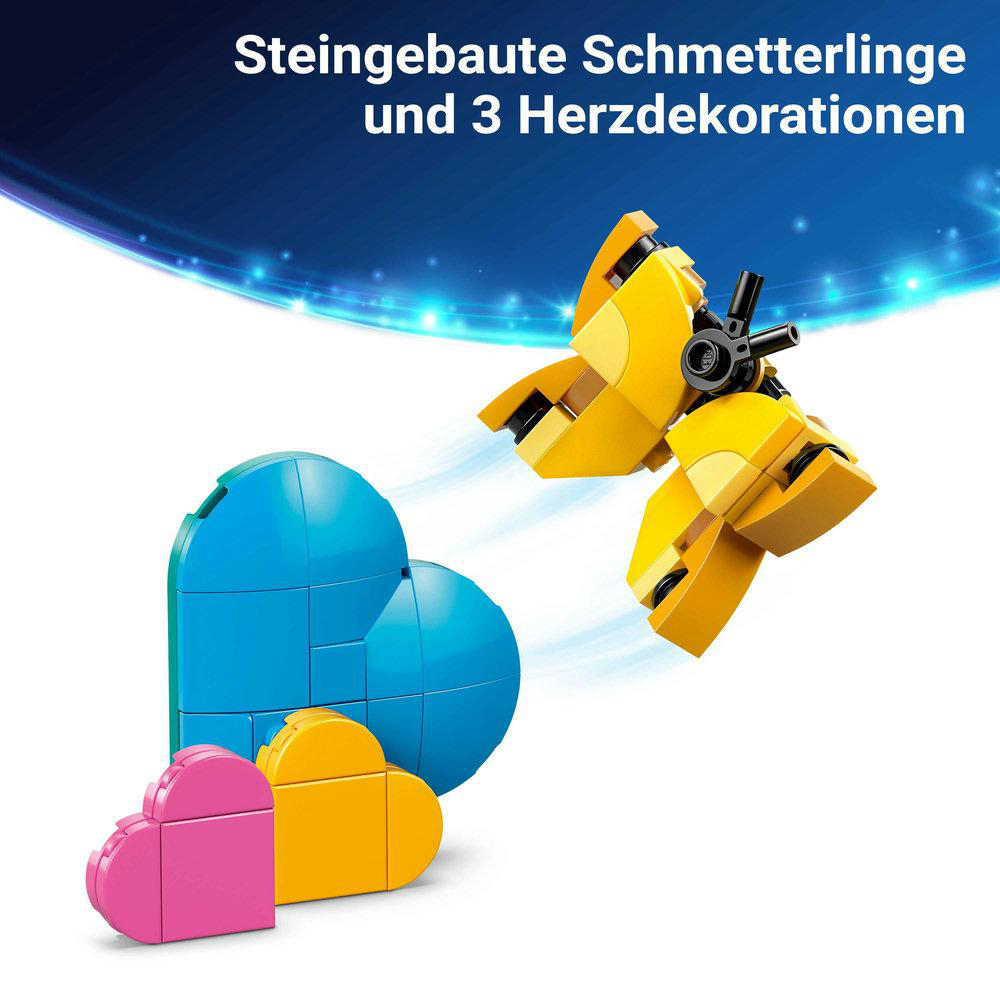 Steinbau-Schmetterling und 3 Herzdekorationen in Gelb, Blau und Pink auf weißem Hintergrund.