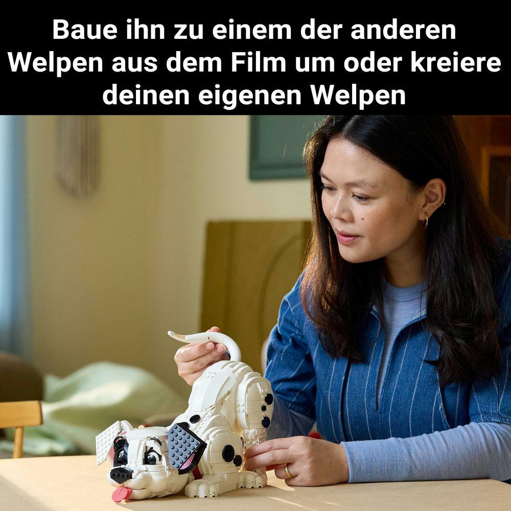 Frau baut Lego Dalmatiner Welpen, mit blauem Hemd und braunen Haaren.