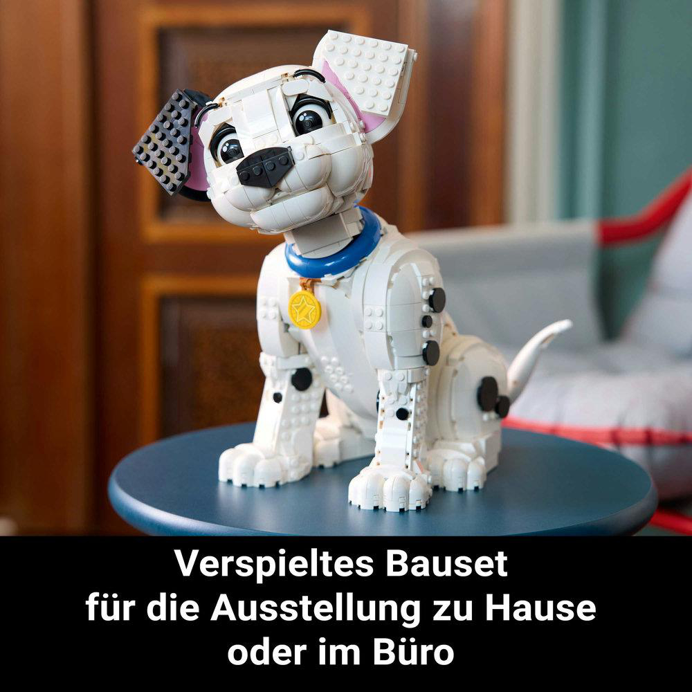 Ein Lego Dalmatiner Welpe sitzt auf einem blauen Tisch. Er hat ein blaues Halsband und ein gelbes Abzeichen.