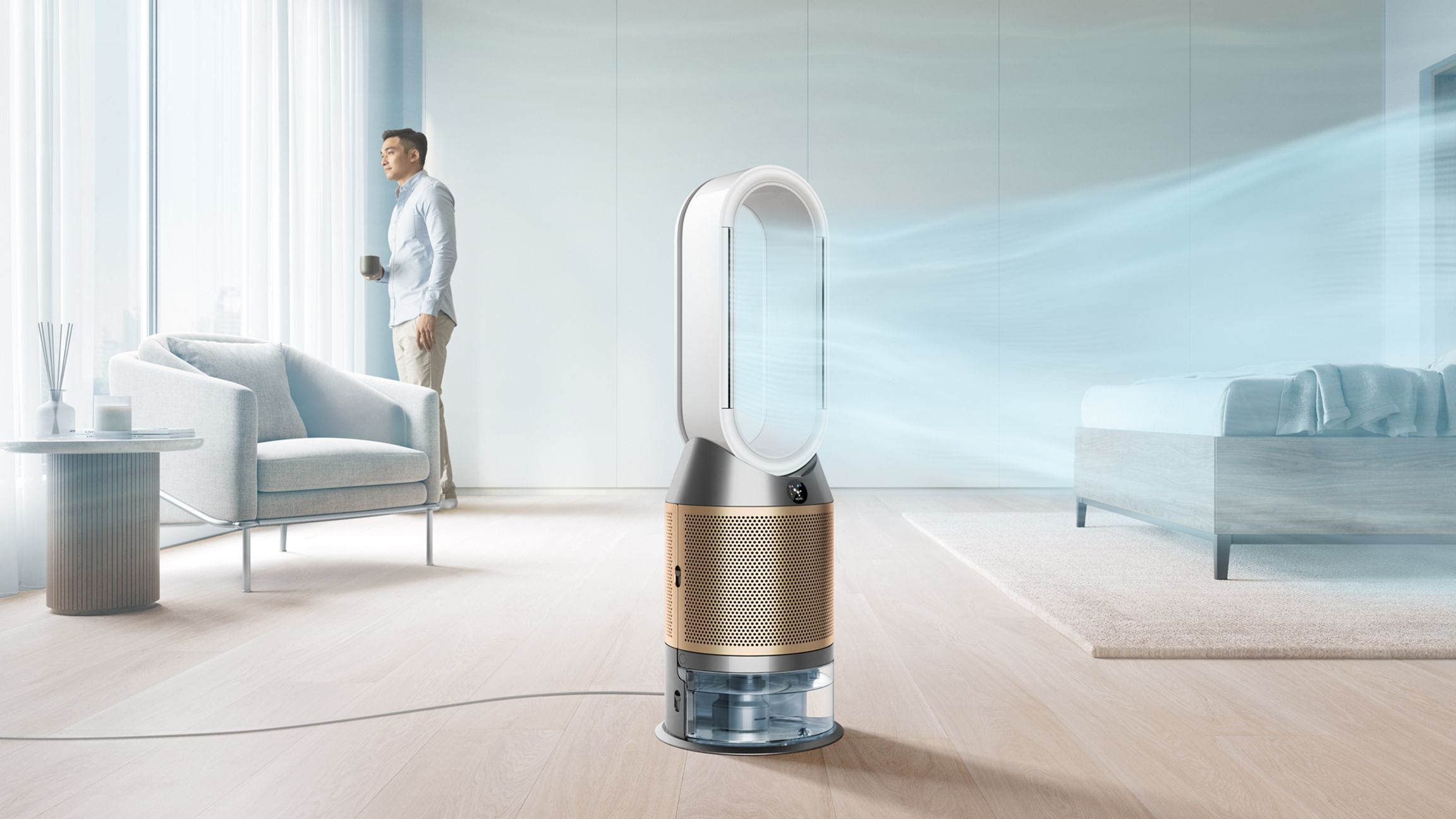 Un purificateur d'air se trouve dans une pièce lumineuse pendant qu'une personne regarde par la fenêtre.