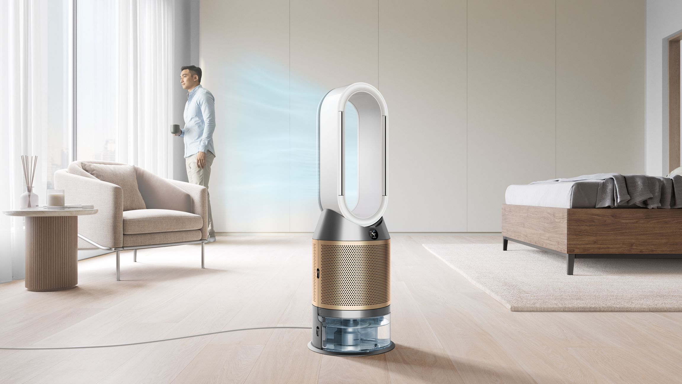 Un homme se tient près d'un purificateur d'air Dyson dans une pièce lumineuse et moderne.