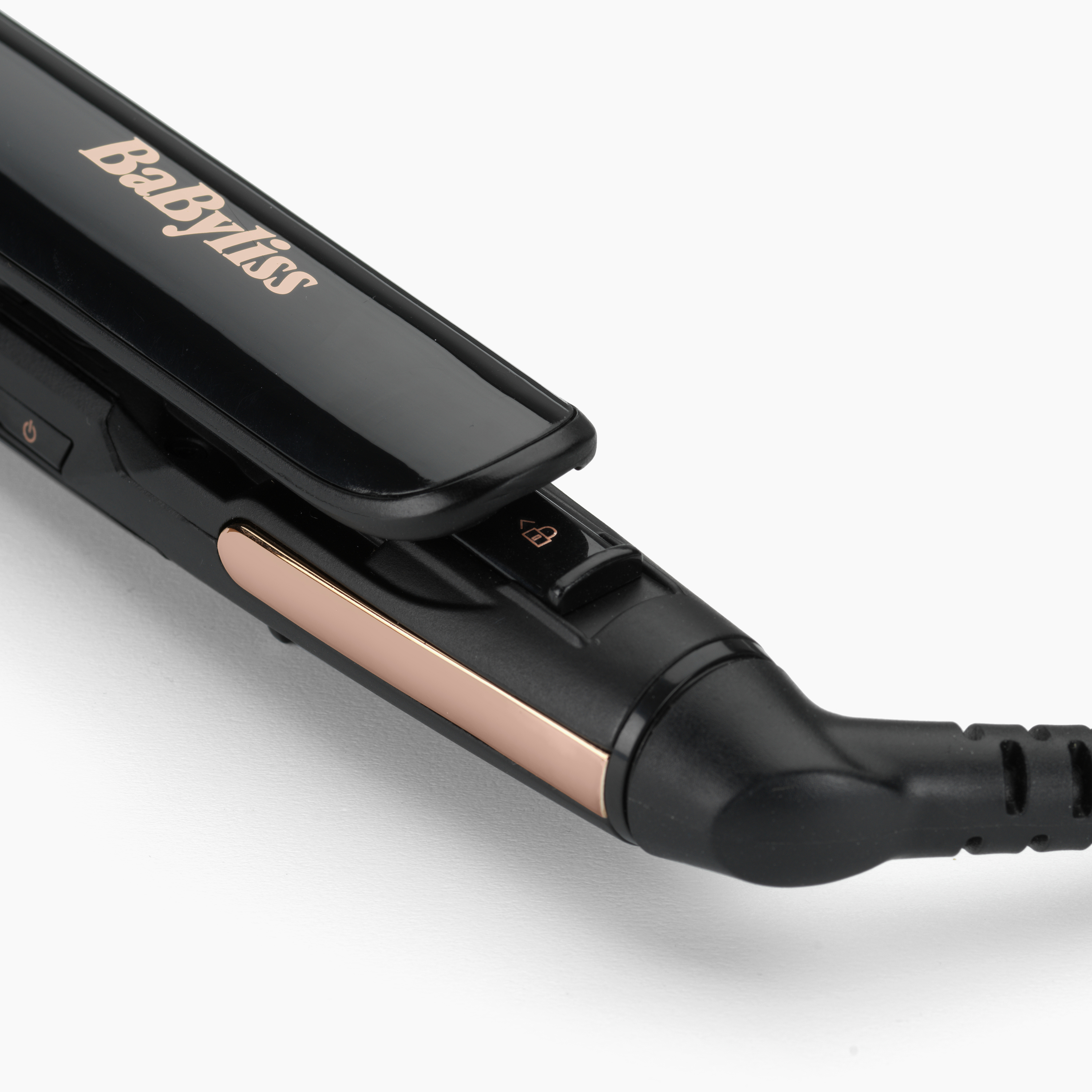 Primo piano di una piastra per capelli Babyliss nera con dettagli dorati su sfondo bianco.