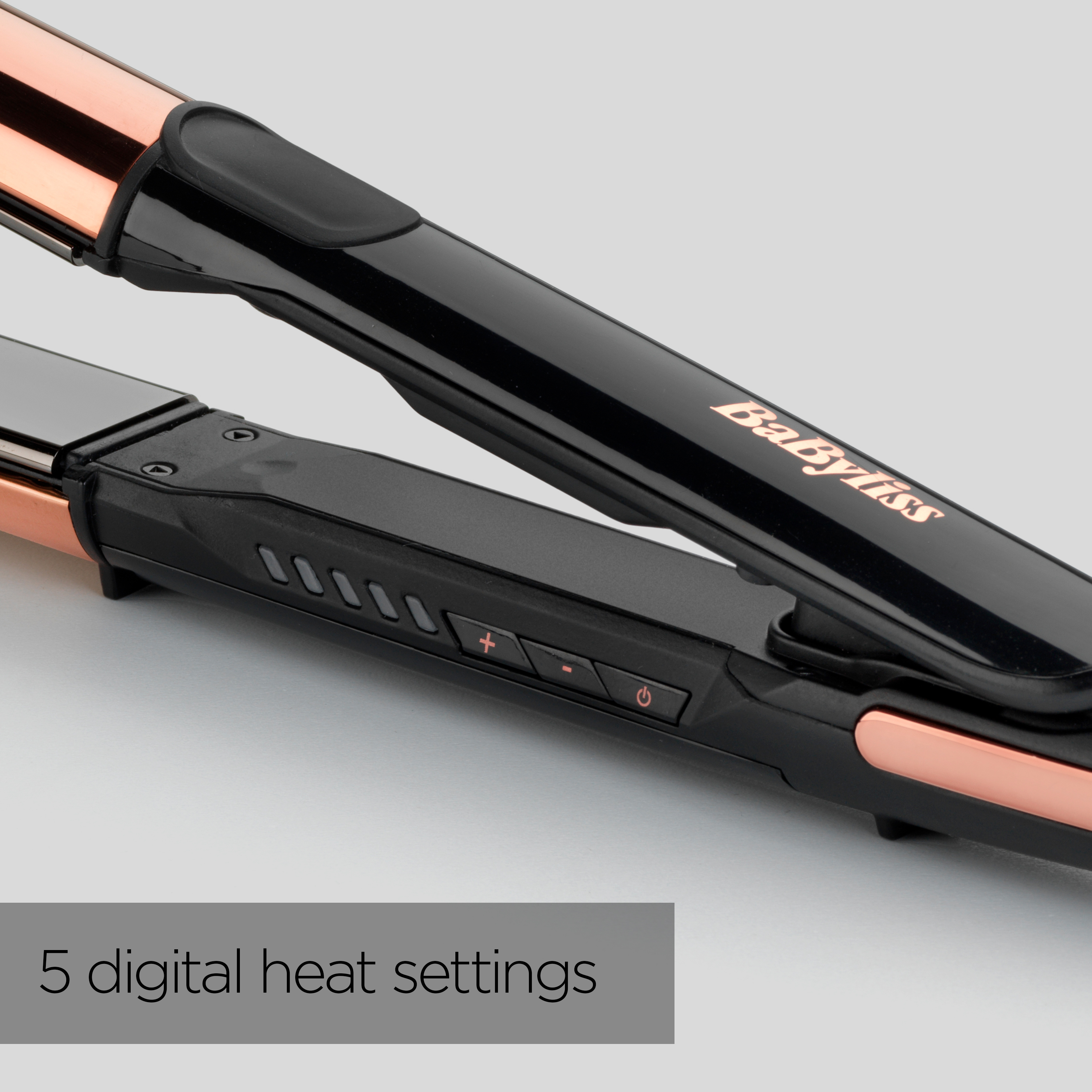 Primo piano di una piastra per capelli Babyliss nera e color rame su sfondo grigio.