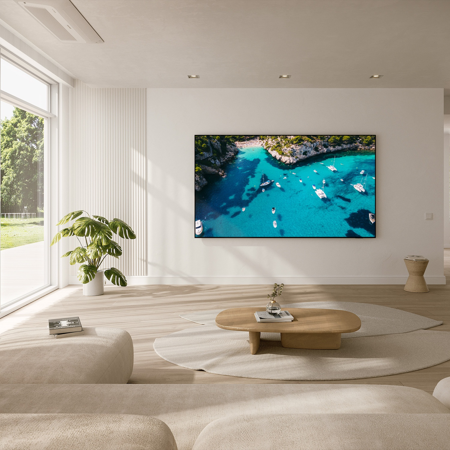 Soggiorno con TV che mostra una scena costiera con barche, mobili dai colori chiari e molta luce naturale.