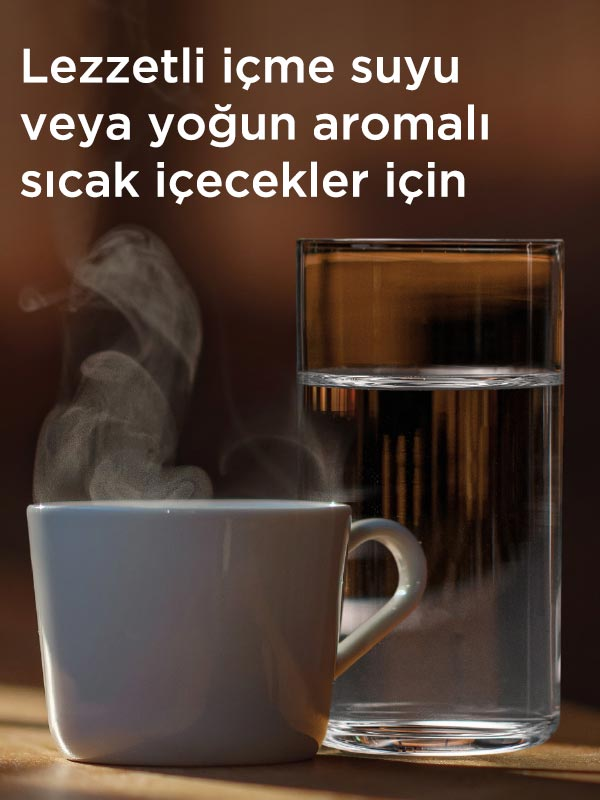 Kahverengi bir arka plan önünde, beyaz bir kupa bir bardak suyun yanında buharlaşıyor.