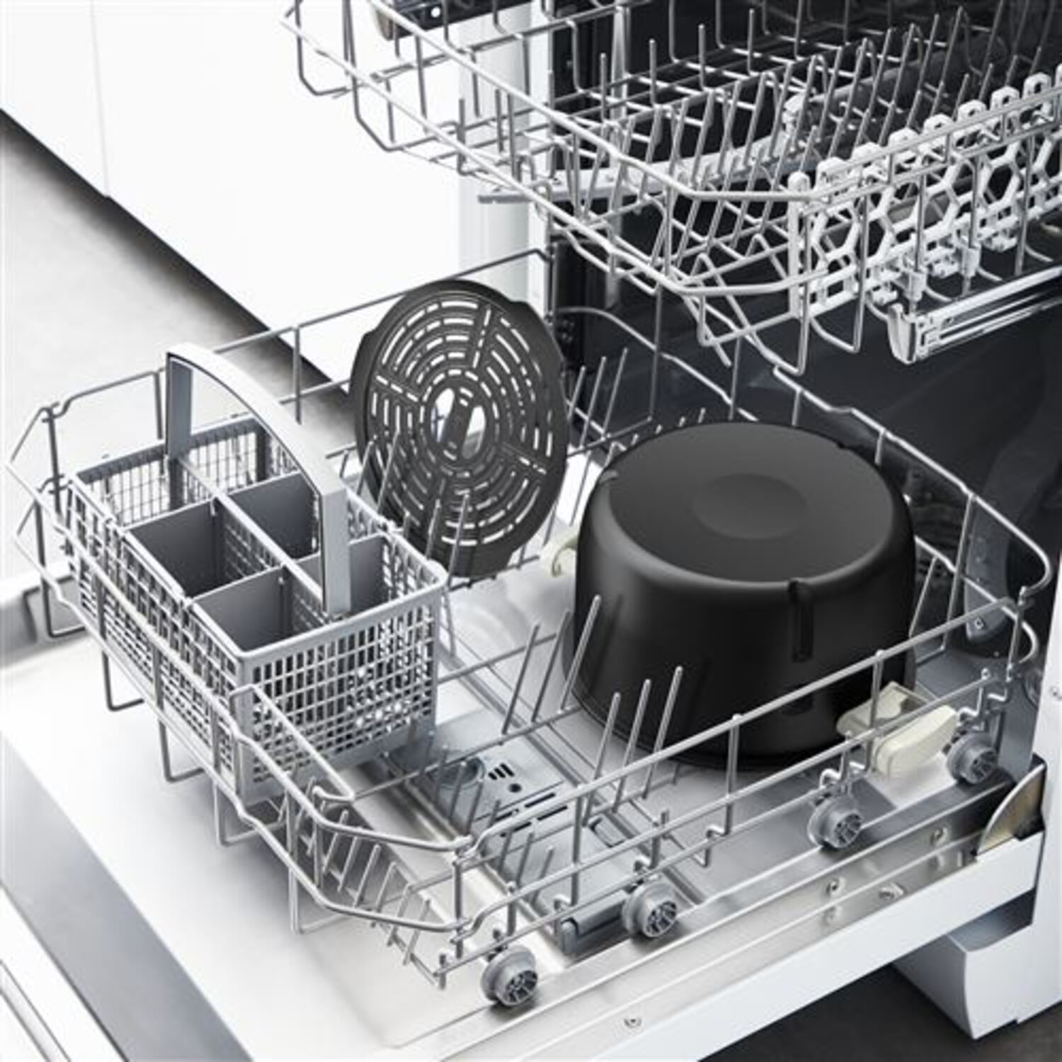 A dishwasher is loaded with dishes, including a black pot and a wire basket.