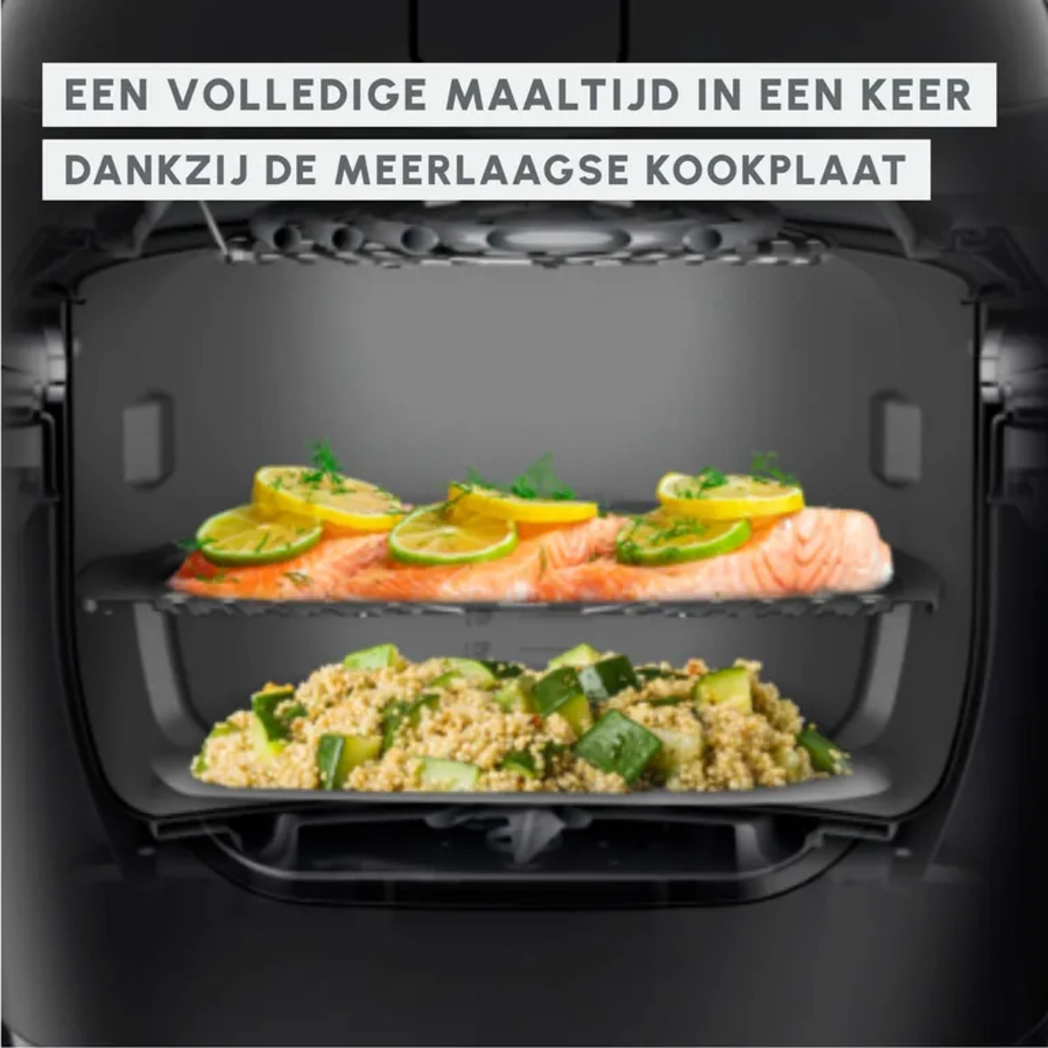 A black air fryer with two tiers cooking salmon with lemon and couscous with zucchini.