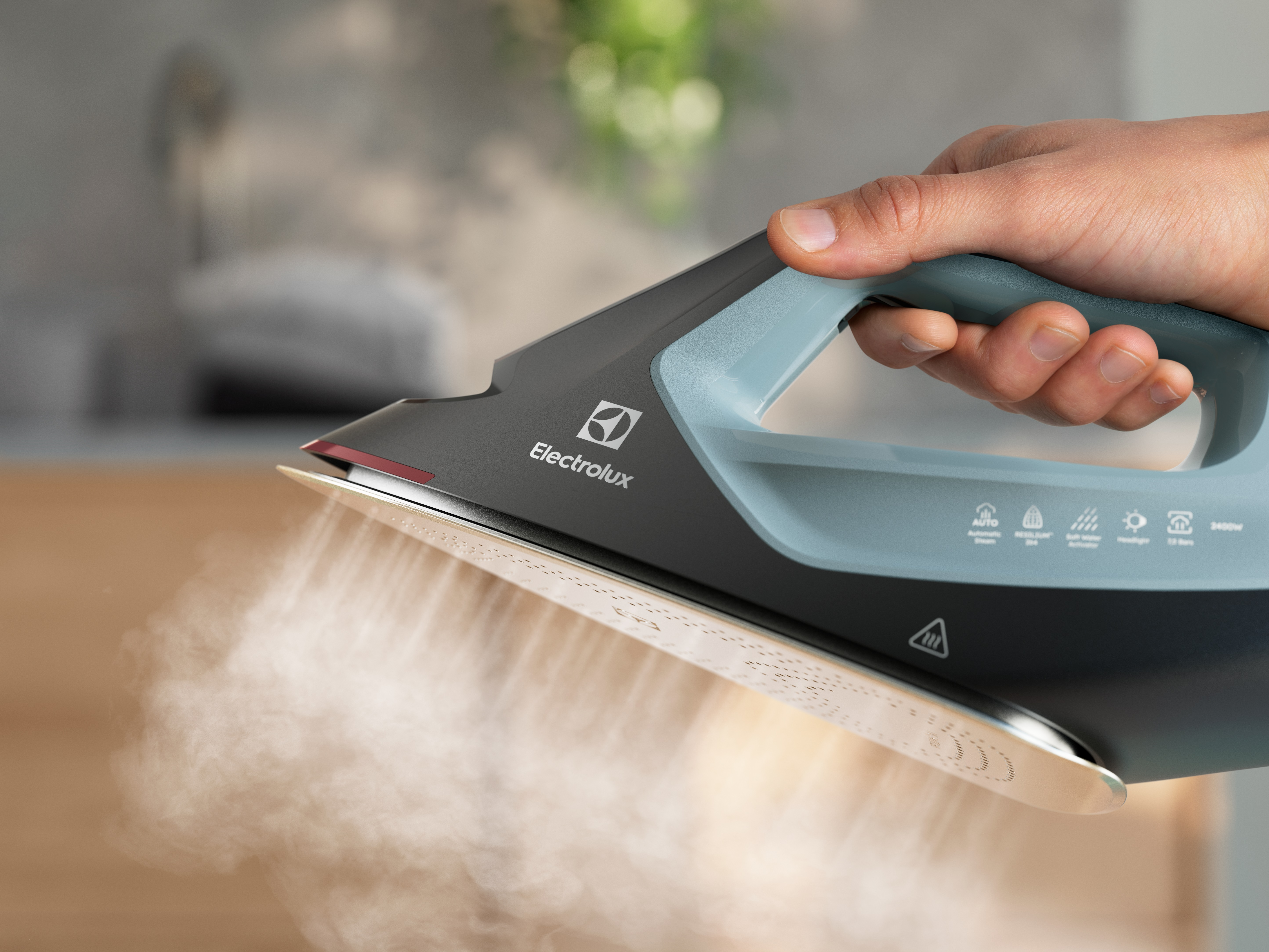 Bir el tarafından tutulan, buharı görülebilen, kullanımda olan bir Electrolux buharlı ütünün yakın çekimi.
