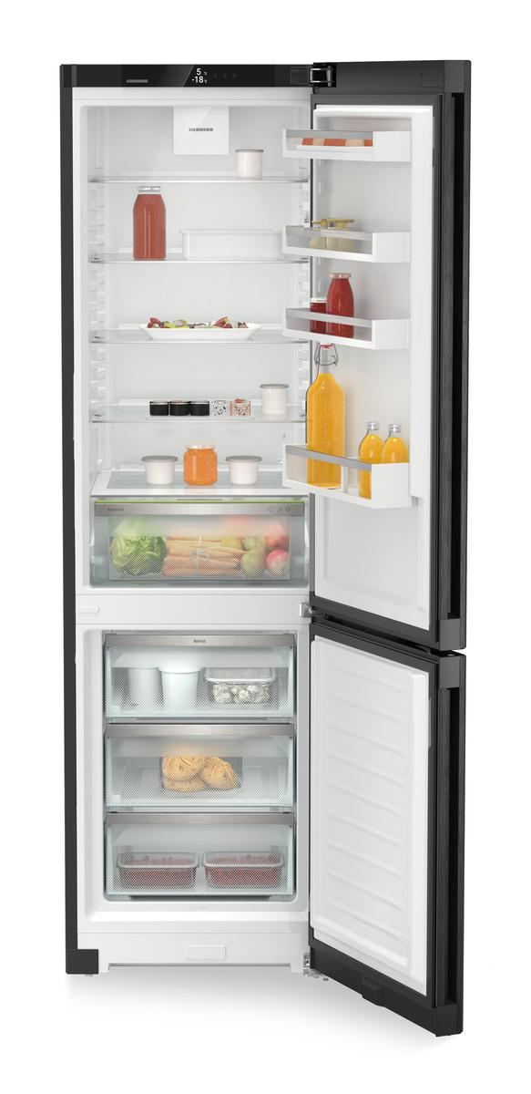 Ein offener Kühlschrank mit Lebensmitteln wie Salat, Karotten und Getränken.