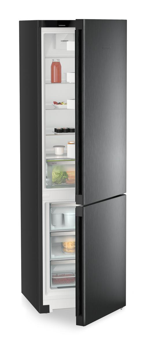 Ein offener, grauer Kühlschrank zeigt Lebensmittel wie Getränke, Gemüse und abgepackte Produkte.