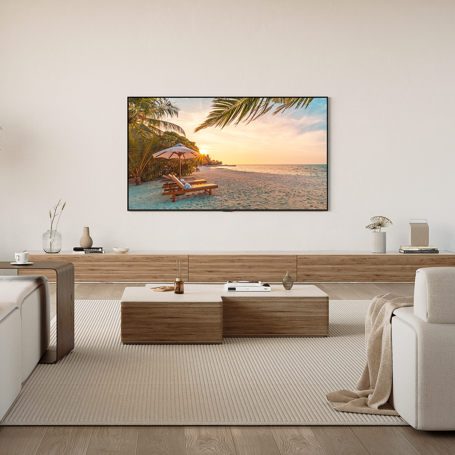 Soggiorno con TV che mostra un tramonto sulla spiaggia, mobili chiari e pavimenti in legno.