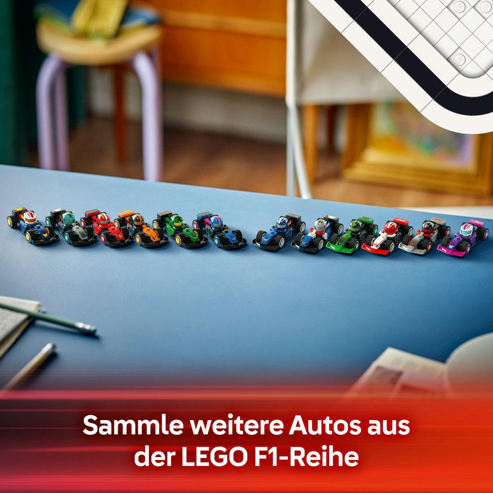Eine Reihe bunter LEGO F1-Autos auf einem blauen Tisch, mit Stuhl und Notizblock im Hintergrund.