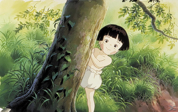 Ein junges Mädchen mit schwarzen Haaren und weißen Shorts blickt hinter einem Baum hervor, in einer grünen, grasbewachsenen Umgebung.