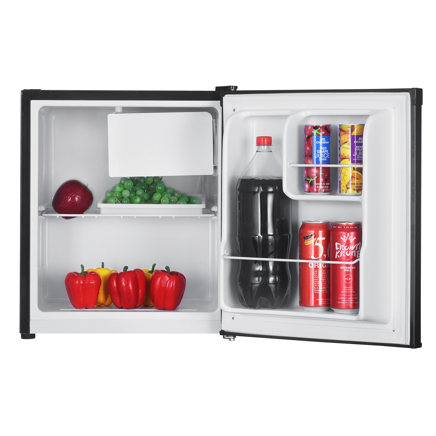 An open mini-fridge contains fruit, juice cans, and a soda bottle. Red, yellow peppers sit below. An apple and grapes are on a shelf.