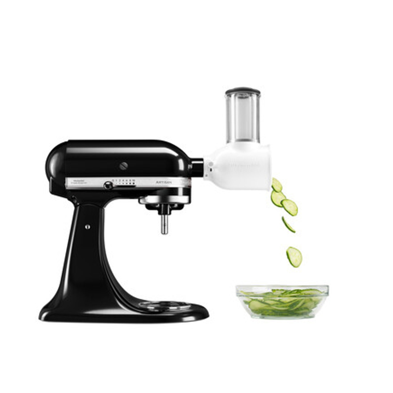 Un mixer KitchenAid nero con un accessorio bianco sta tagliando cetrioli in una ciotola trasparente. I cetrioli affettati cadono dall'accessorio.