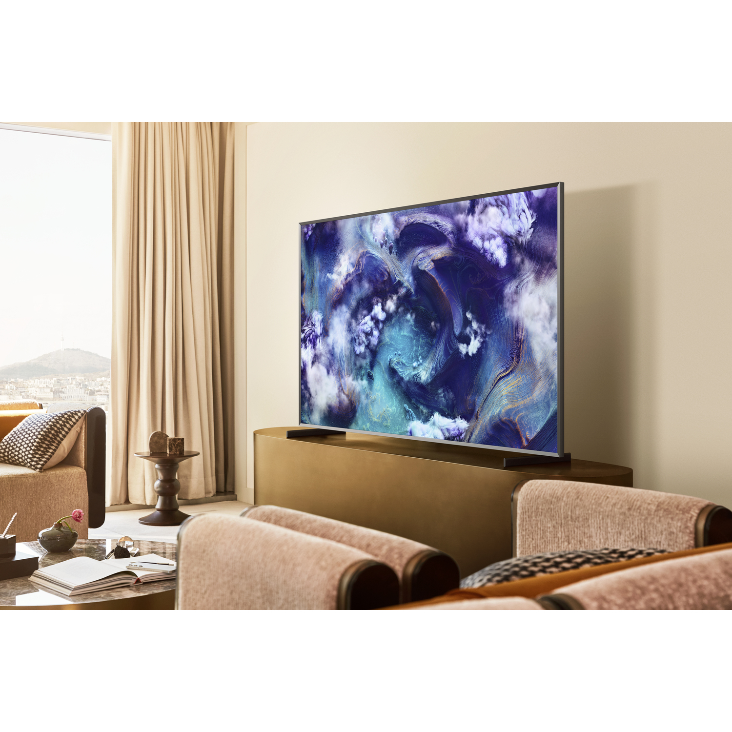 A living room with a TV on a cabinet. The screen displays a blue-purple abstract pattern.