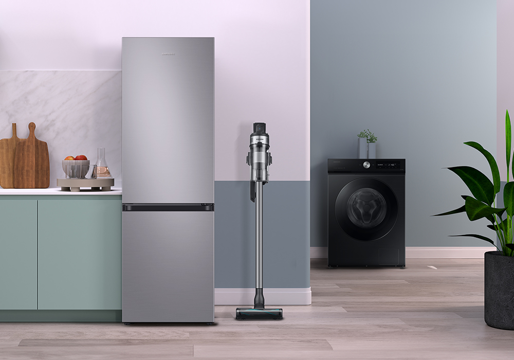 Keuken met koelkast, wasmachine, stofzuiger en planten. Heldere kleuren en modern design.
