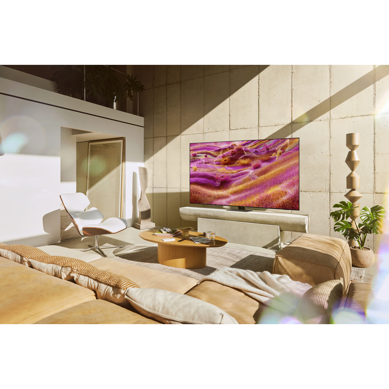 A living room with a TV showing a colorful image. A sofa and a chair are also present.