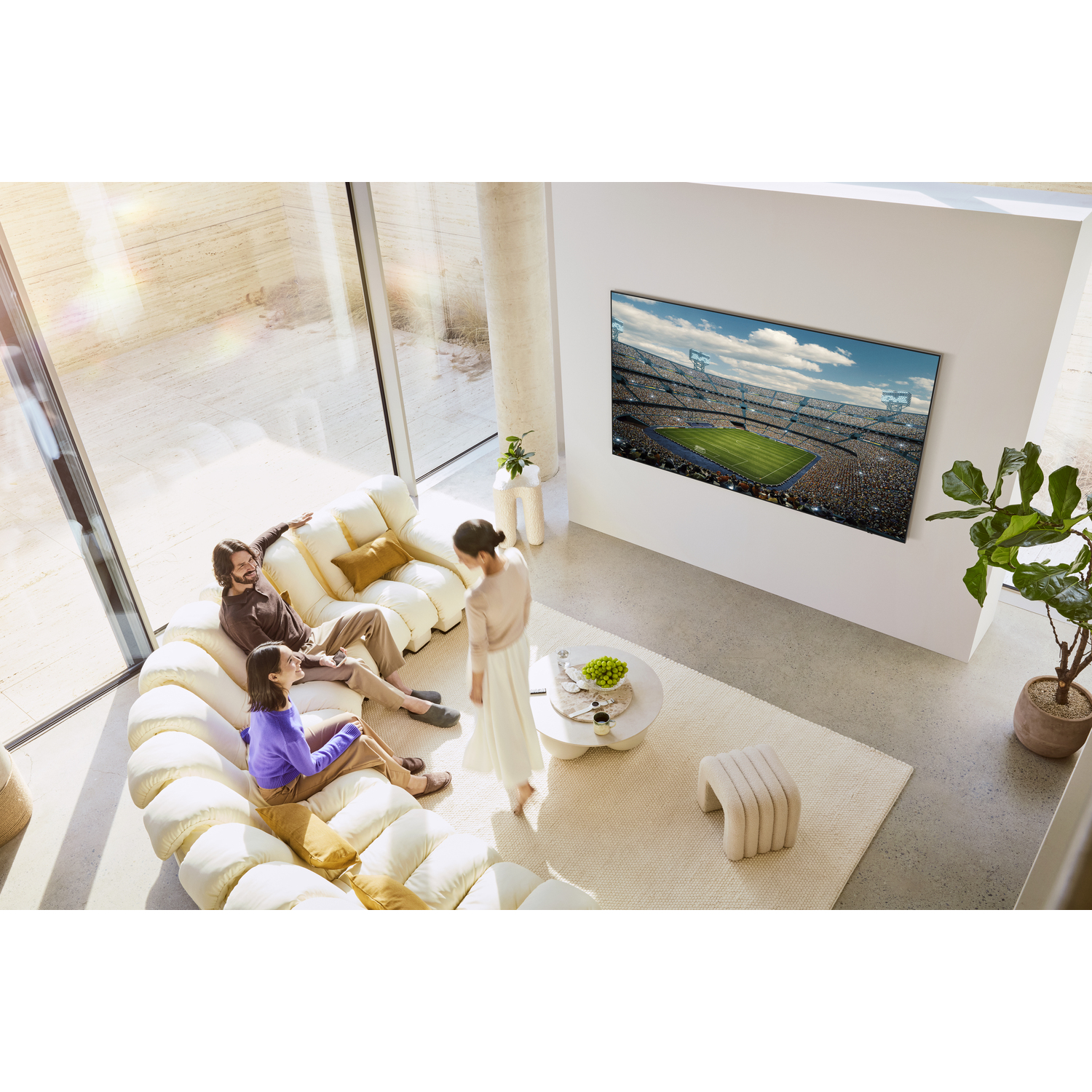 A living room with a group of people watching TV. A football game is visible on the television.