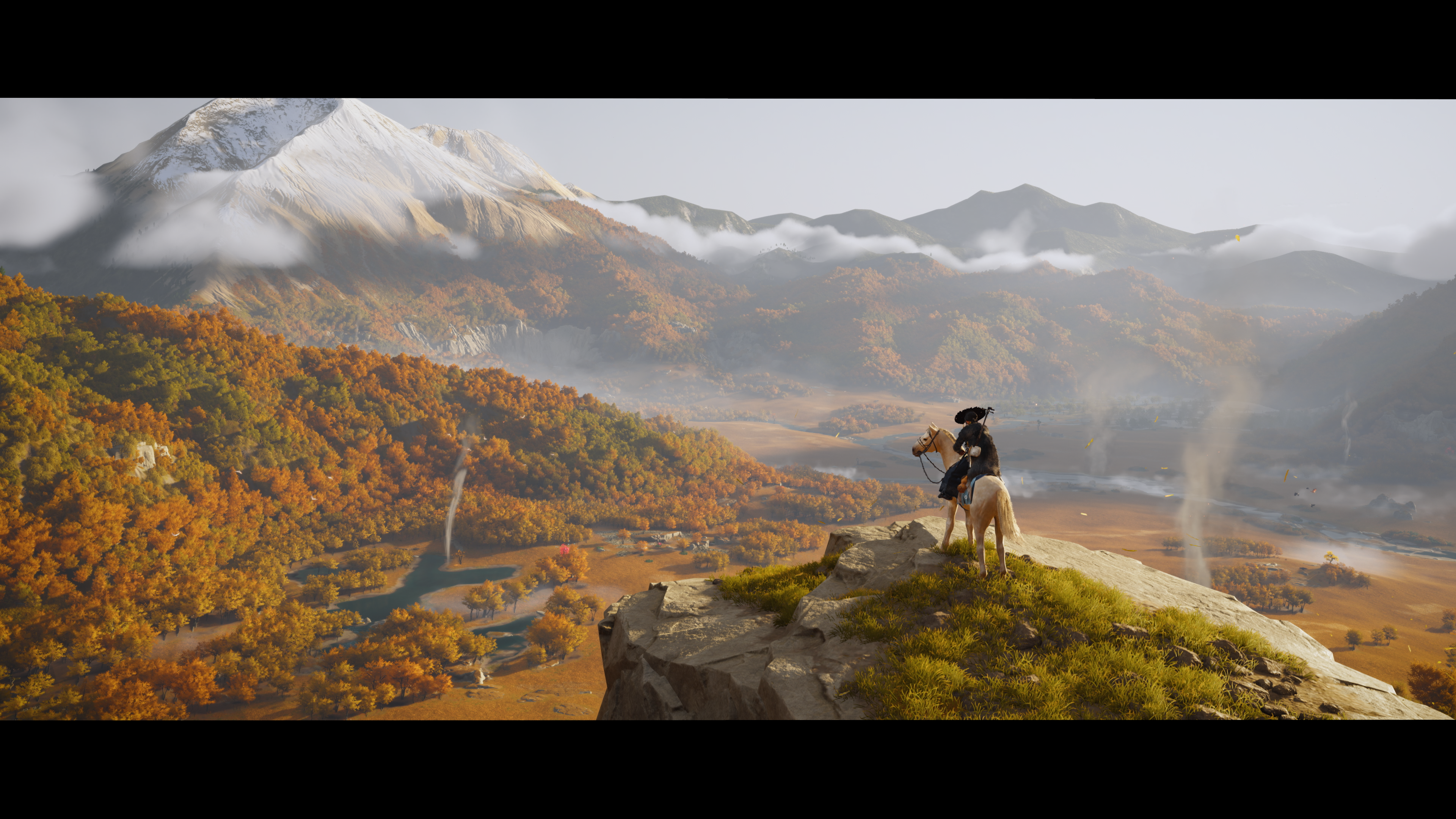 Eine Person reitet auf einem Pferd auf einem Felsen mit Blick auf eine herbstliche Berglandschaft mit Schneebergen im Hintergrund.