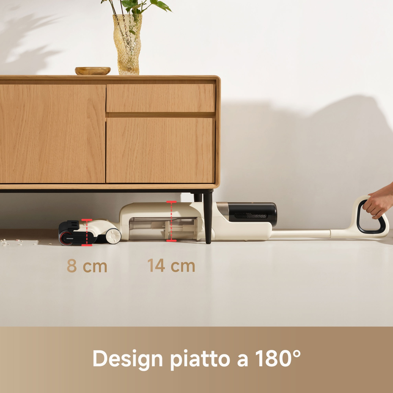 Strumento di pulizia beige sotto un mobile in legno, con misure. Su un pavimento bianco.