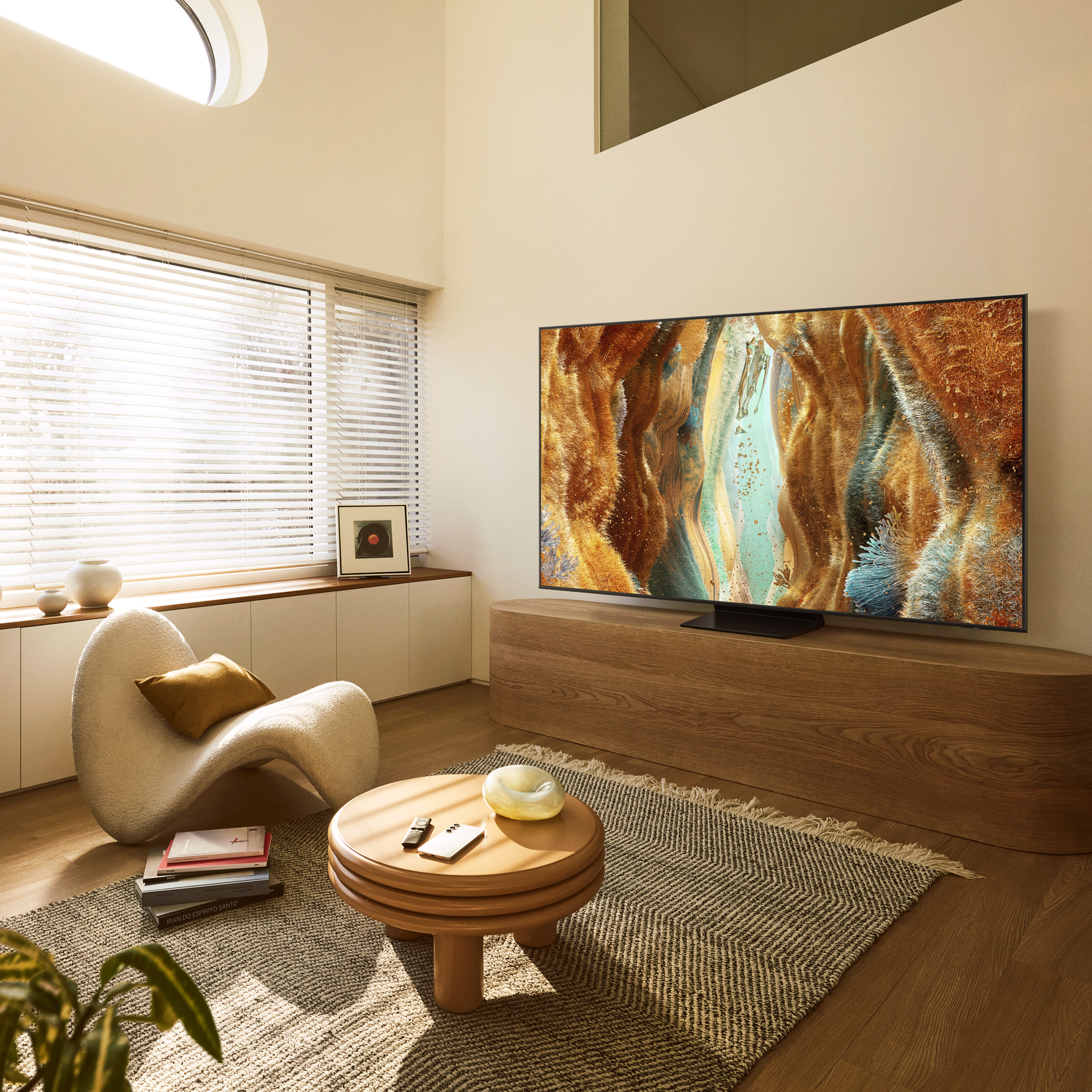 Een woonkamer met een tv, een fauteuil, een salontafel en een raam op de achtergrond.