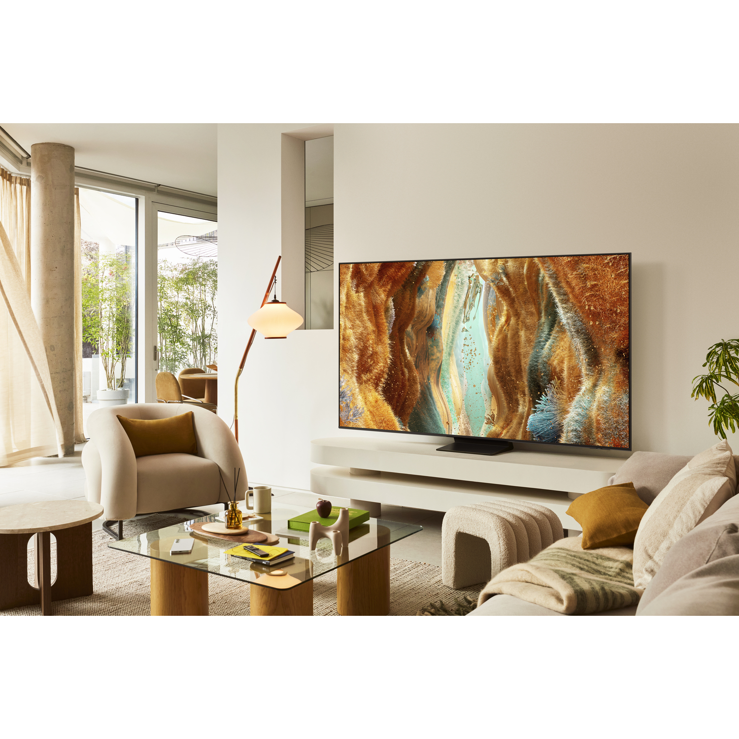 Living room with sofa, table and TV showing colorful image. Windows and lamp are in the background.