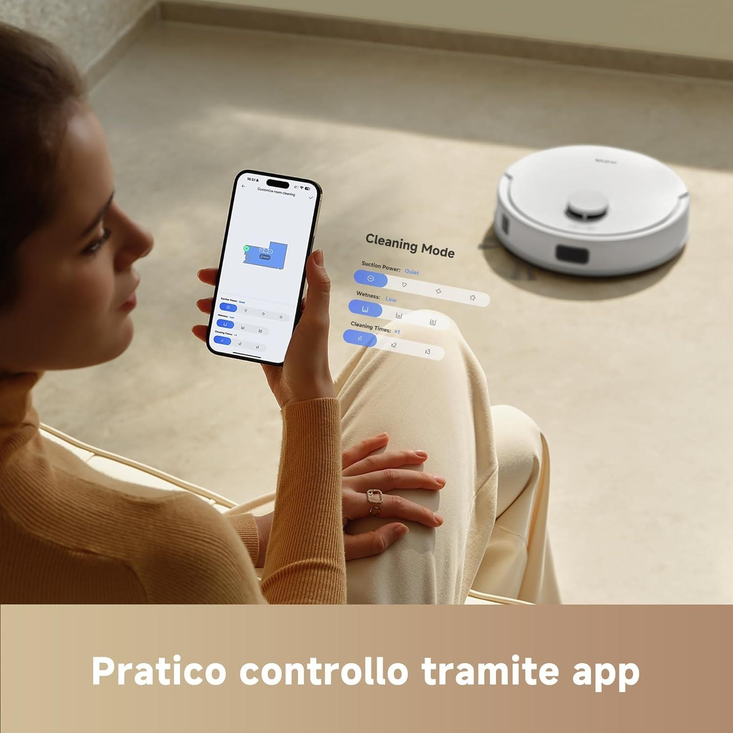 Una donna controlla un aspirapolvere robot tramite un'app per smartphone mentre è seduta.