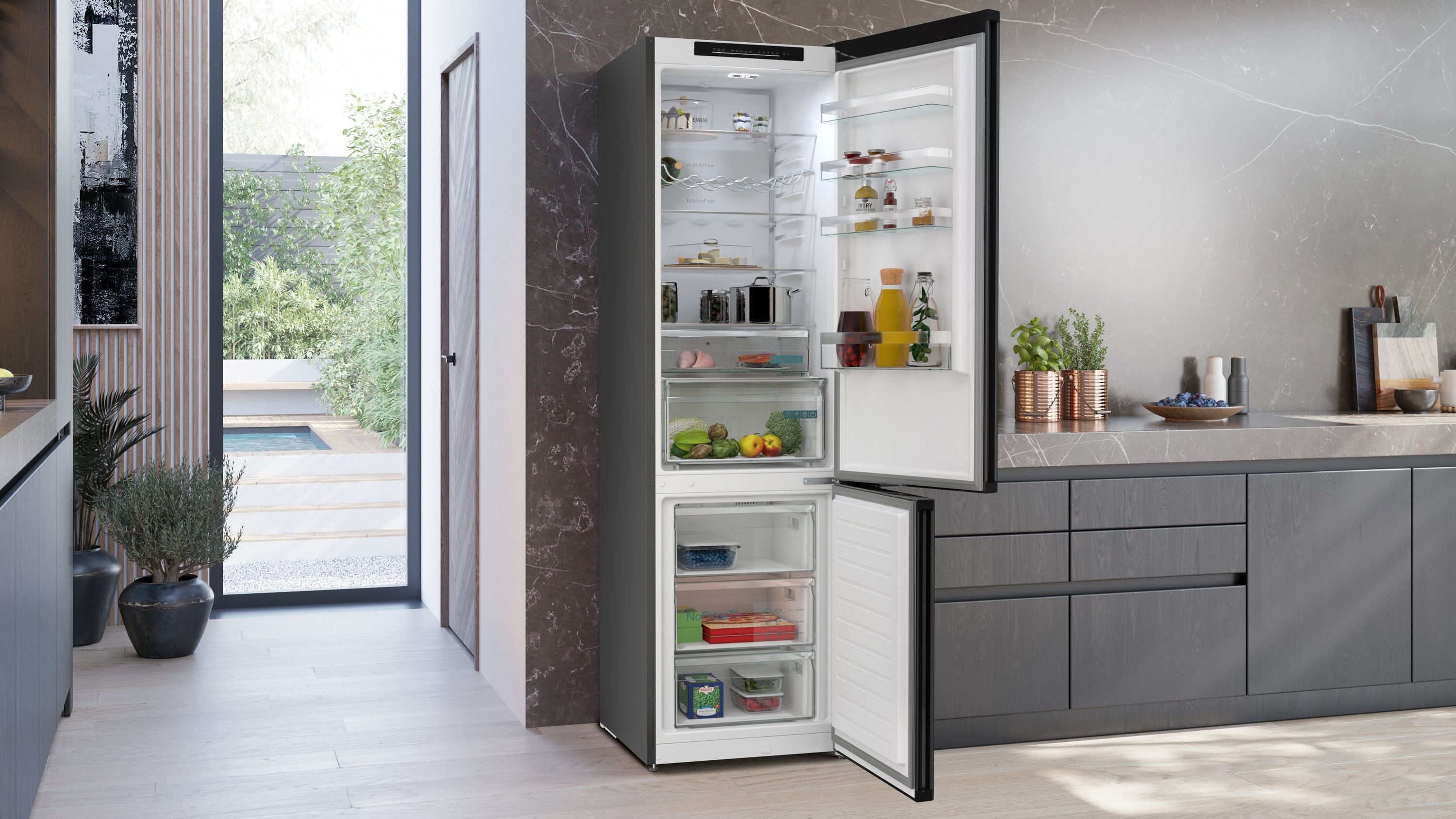 Küche mit geöffnetem Kühlschrank. Innenraum mit Lebensmitteln, Schubladen und Regalen. Fenster im Hintergrund.