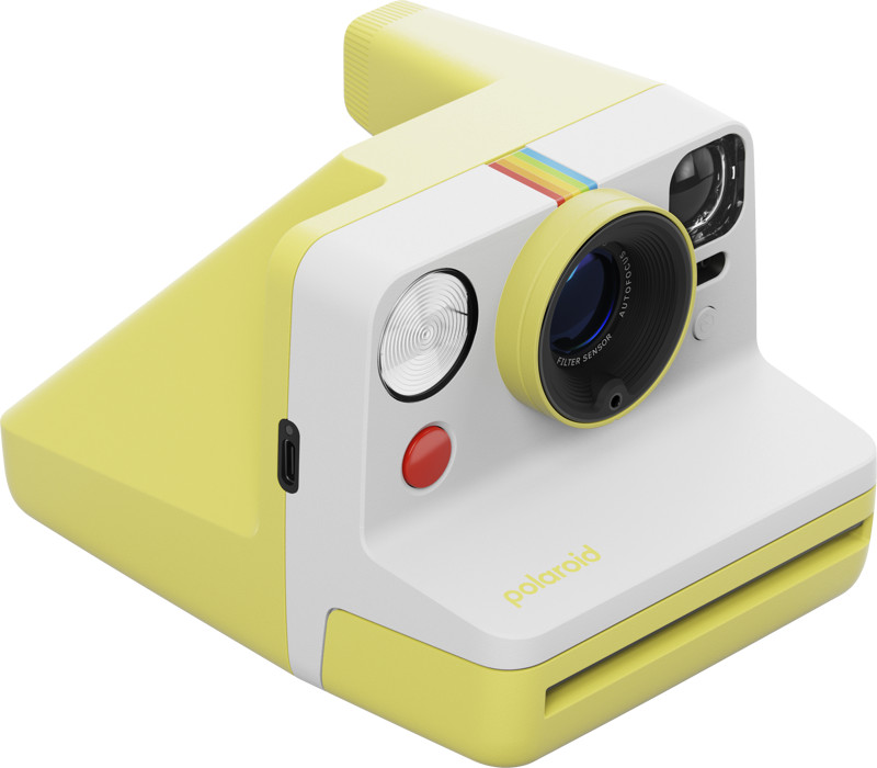 Żółty aparat Polaroid pod kątem z tęczowym paskiem i czerwonym przyciskiem.