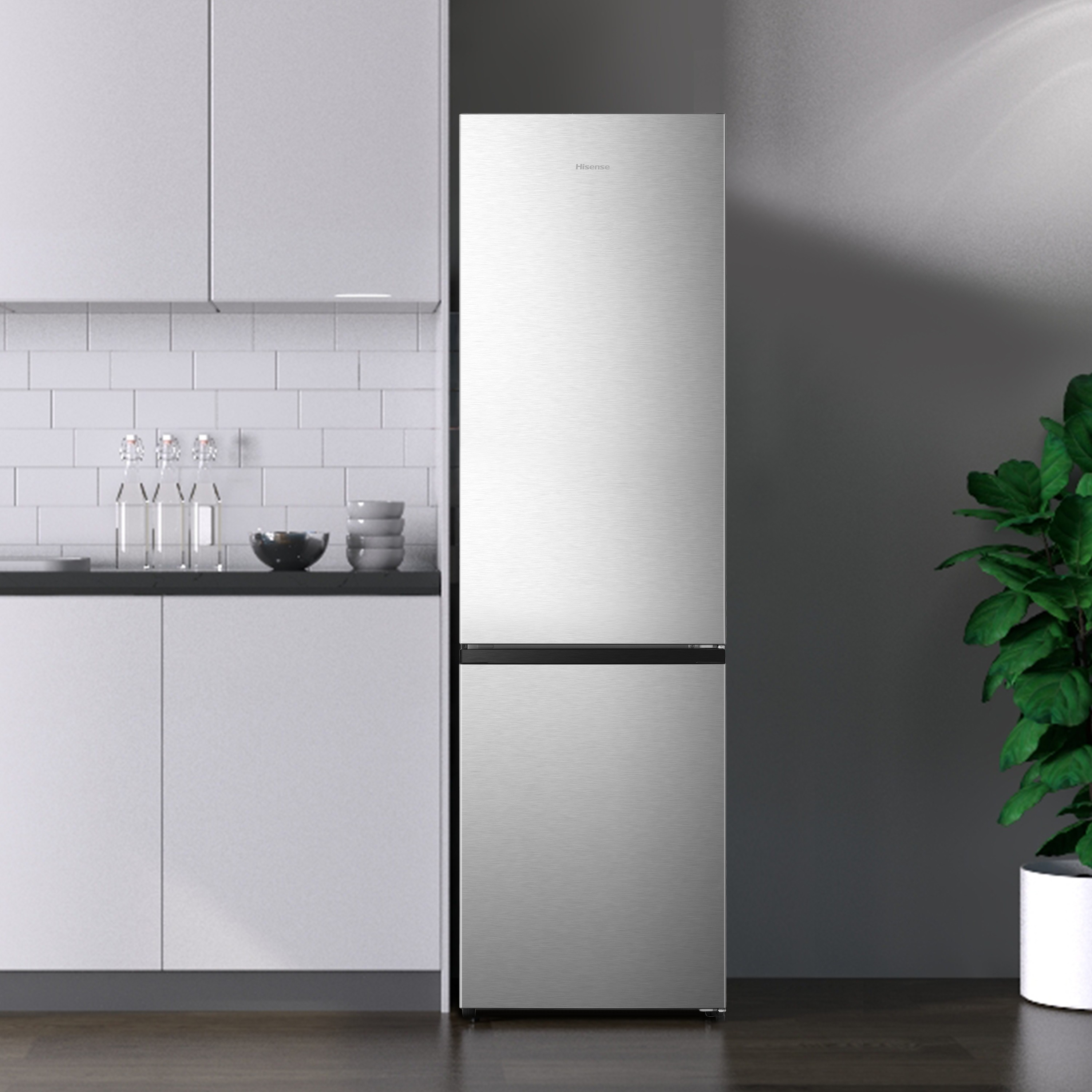 Refrigerador plateado con dos puertas, contra una pared blanca con elementos negros.