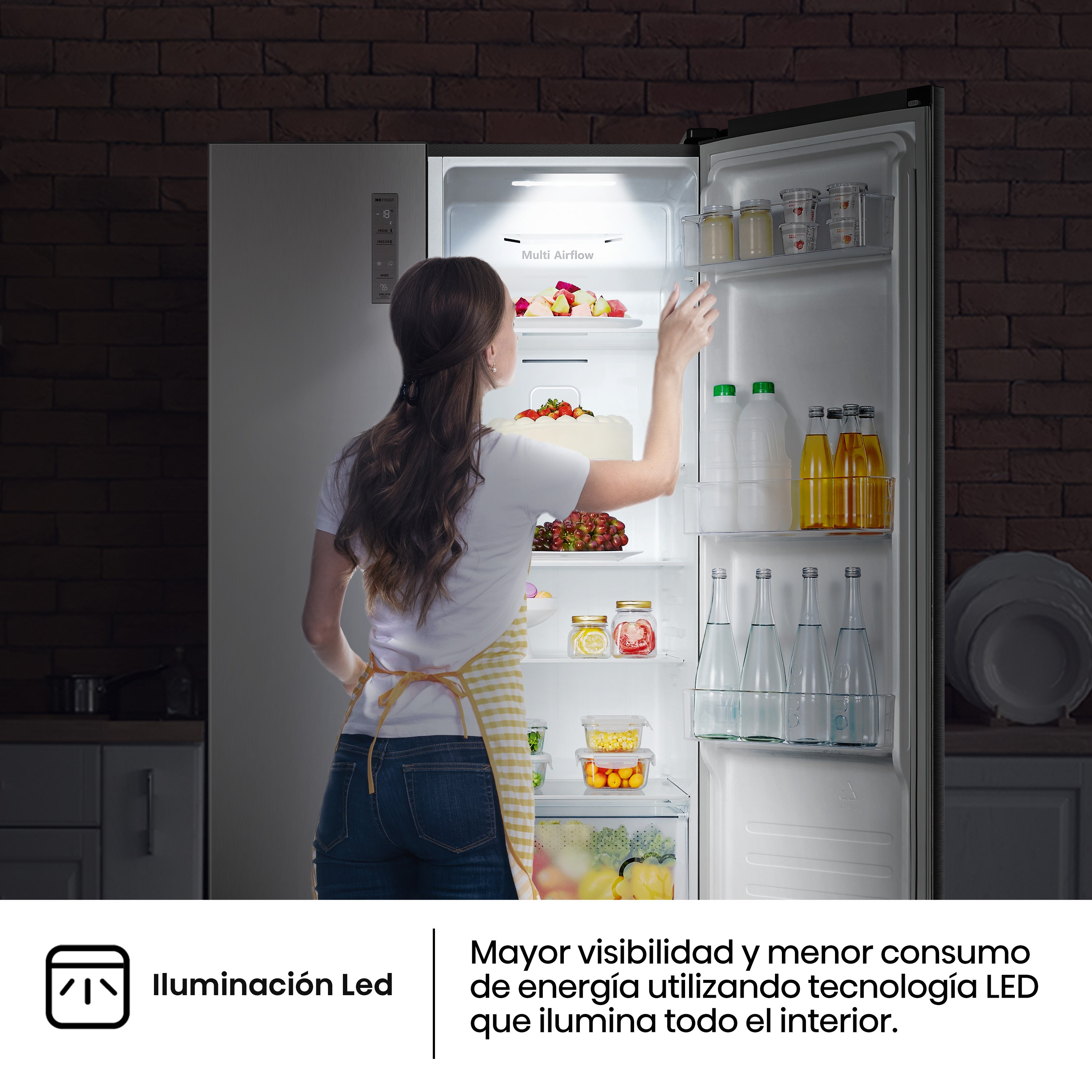 Una mujer abriendo un refrigerador, equipado con iluminación LED.