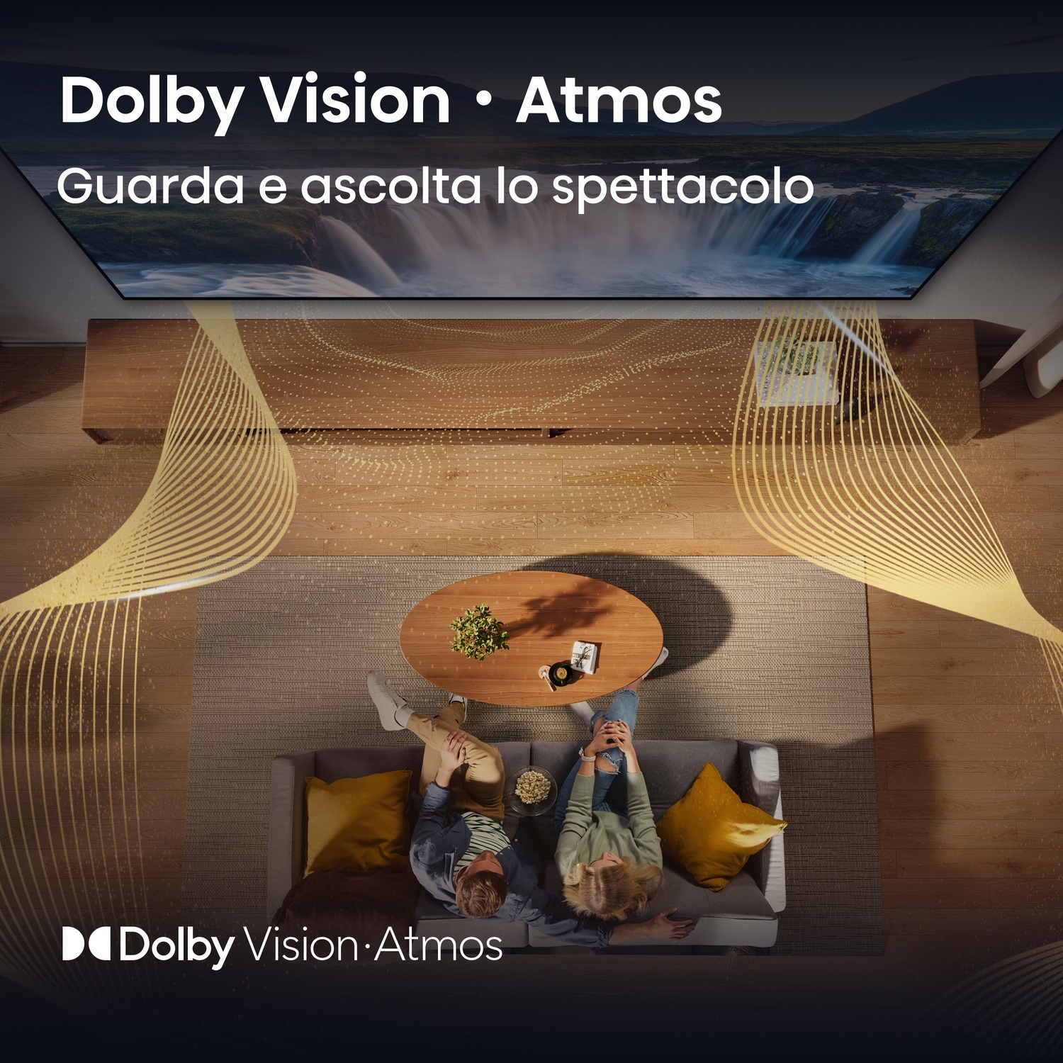 Due persone su un divano che guardano la TV, con una scena di cascata sullo schermo.