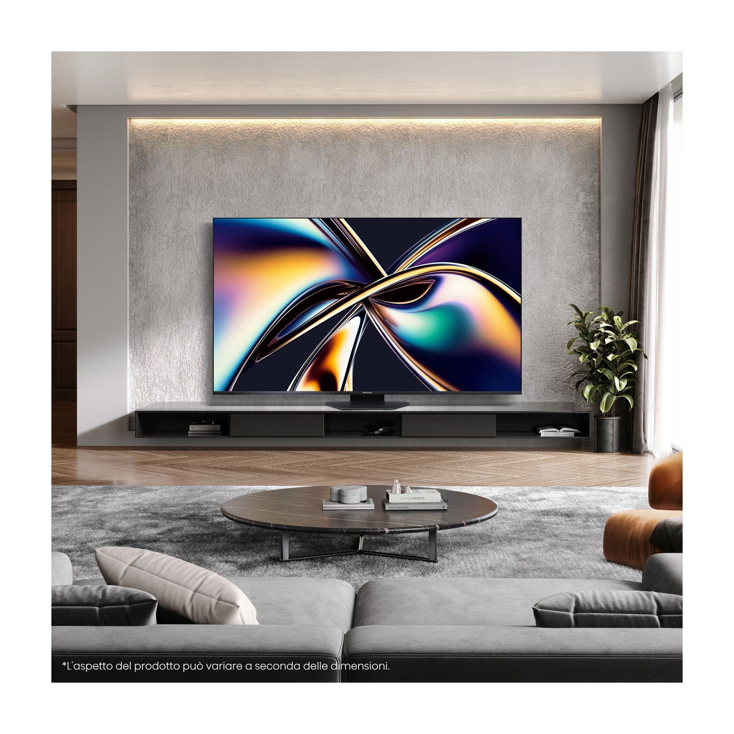 Un televisore in un soggiorno moderno mostra un motivo astratto e colorato. Sono visibili un divano grigio, un tavolo rotondo e una pianta.