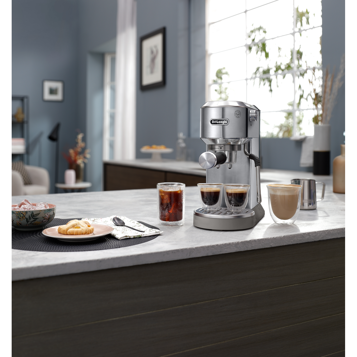An espresso machine on a countertop with drinks and decor. Blue background.