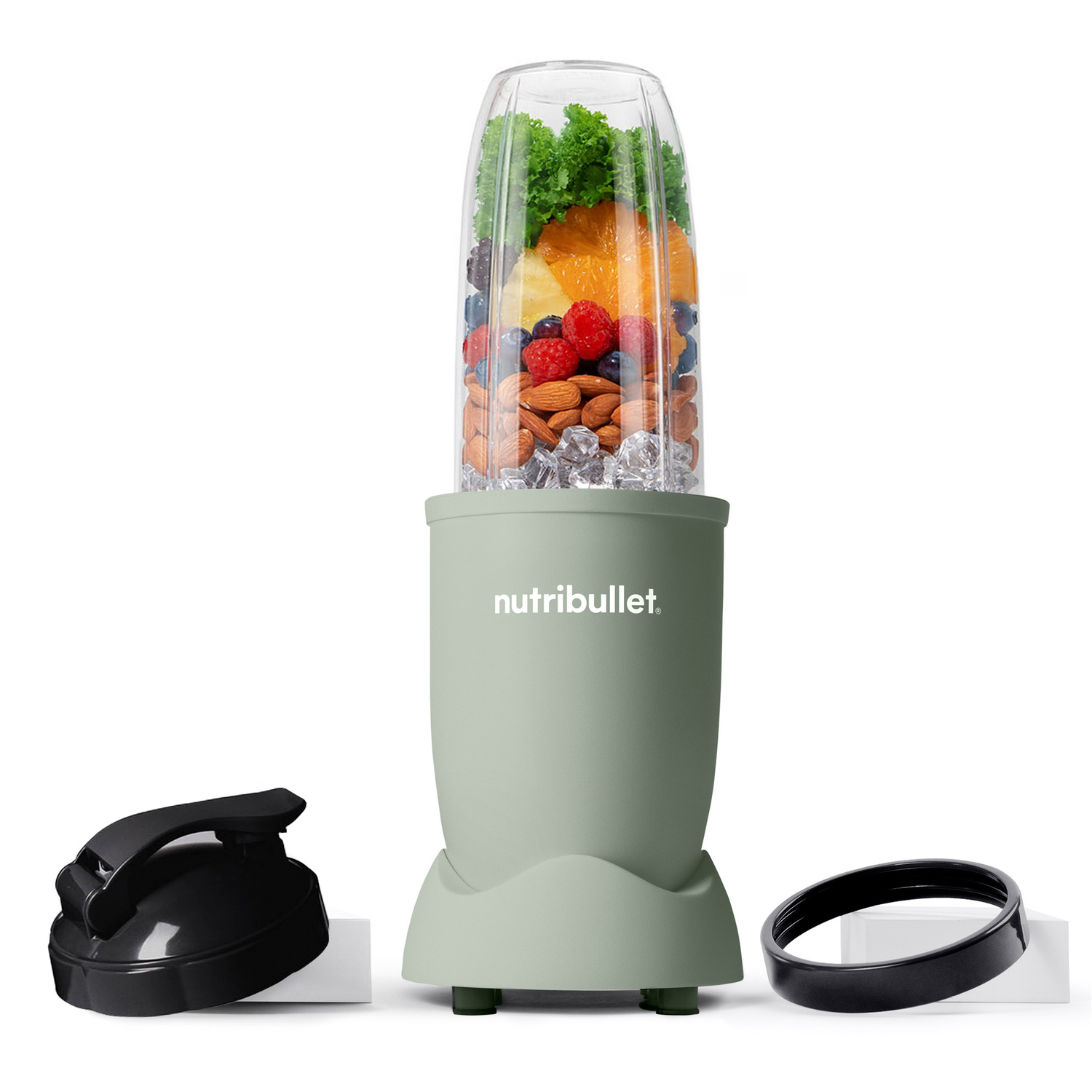 A green Nutribullet blender with fruits and ice cubes. Accessories: black lid and ring. On a white background.