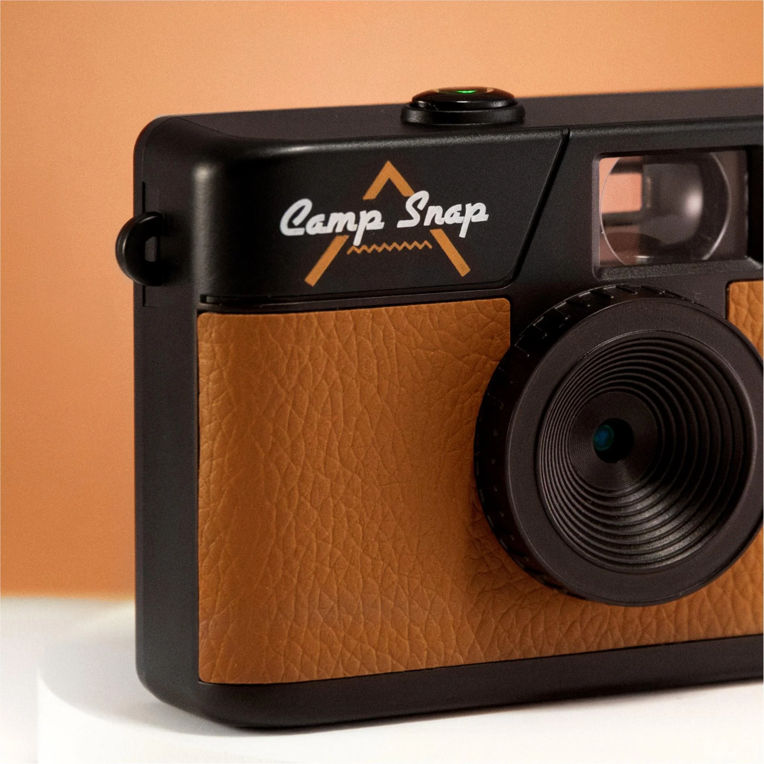 A black and brown camera with the words 'Camp Snap'. The lens is black, and the body has a leather-like brown texture.