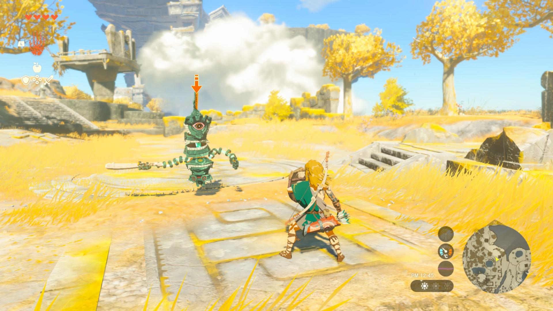 Link steht vor einem Roboter in einer gelben Graslandschaft mit Bäumen und Ruinen im Hintergrund.