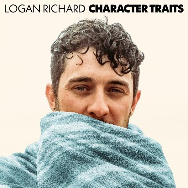 Mann mit lockigem Haar, eingewickelt in ein blaues Handtuch. Der Text oben lautet 'LOGAN RICHARD CHARACTER TRAITS'.