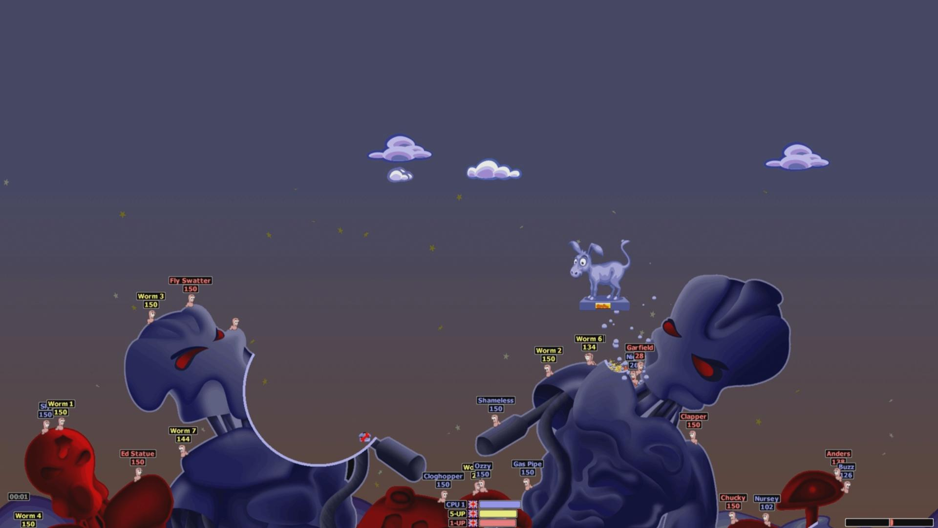 Eine Videospielszenen mit Würmern, die auf dunklem Hintergrund kämpfen. Eselstatue und Wolken am Himmel, Roboter und Würmer am Boden.