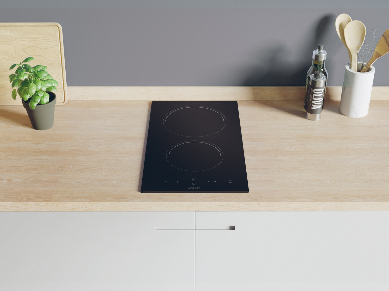Placa de cocina sobre encimera de madera, con plantas y utensilios de cocina detrás. Armarios blancos abajo.
