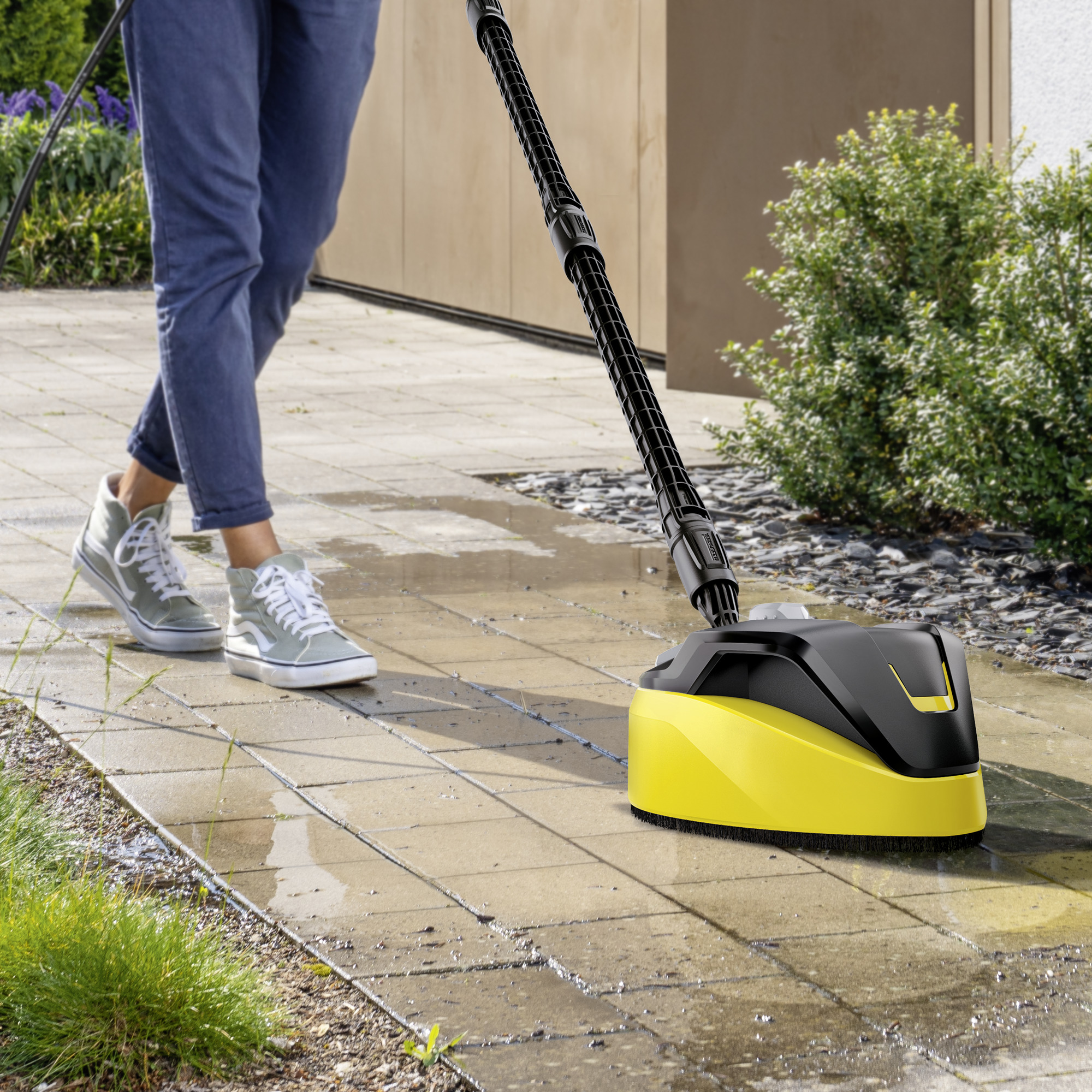 Osoba czyszcząca chodnik za pomocą obrotowej myjki do powierzchni.