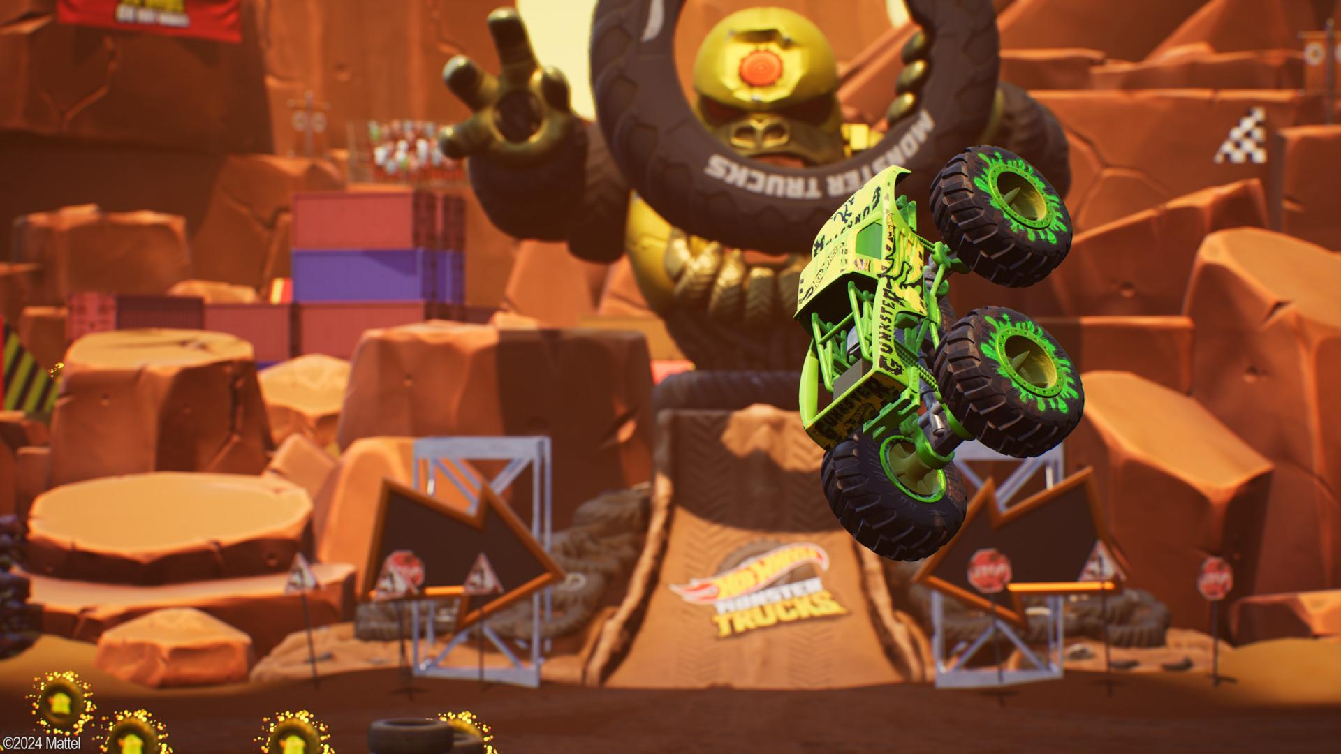 Ein grüner Monstertruck springt in der Luft, vor einem großen Monster und einer Rennstrecke.